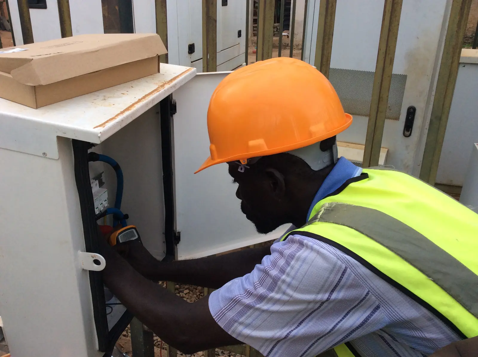 Technician working inside an outdoor telecommunications cabinet