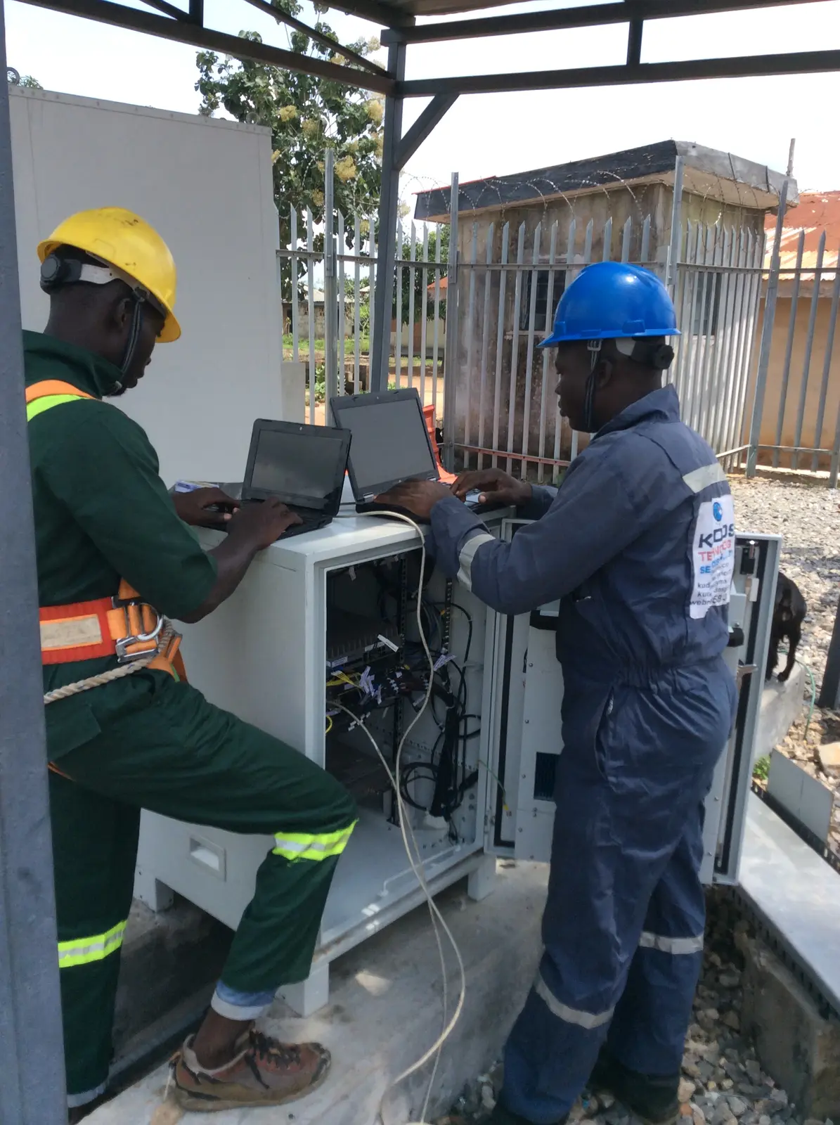 Engineering team testing equipment with a laptop at a project site