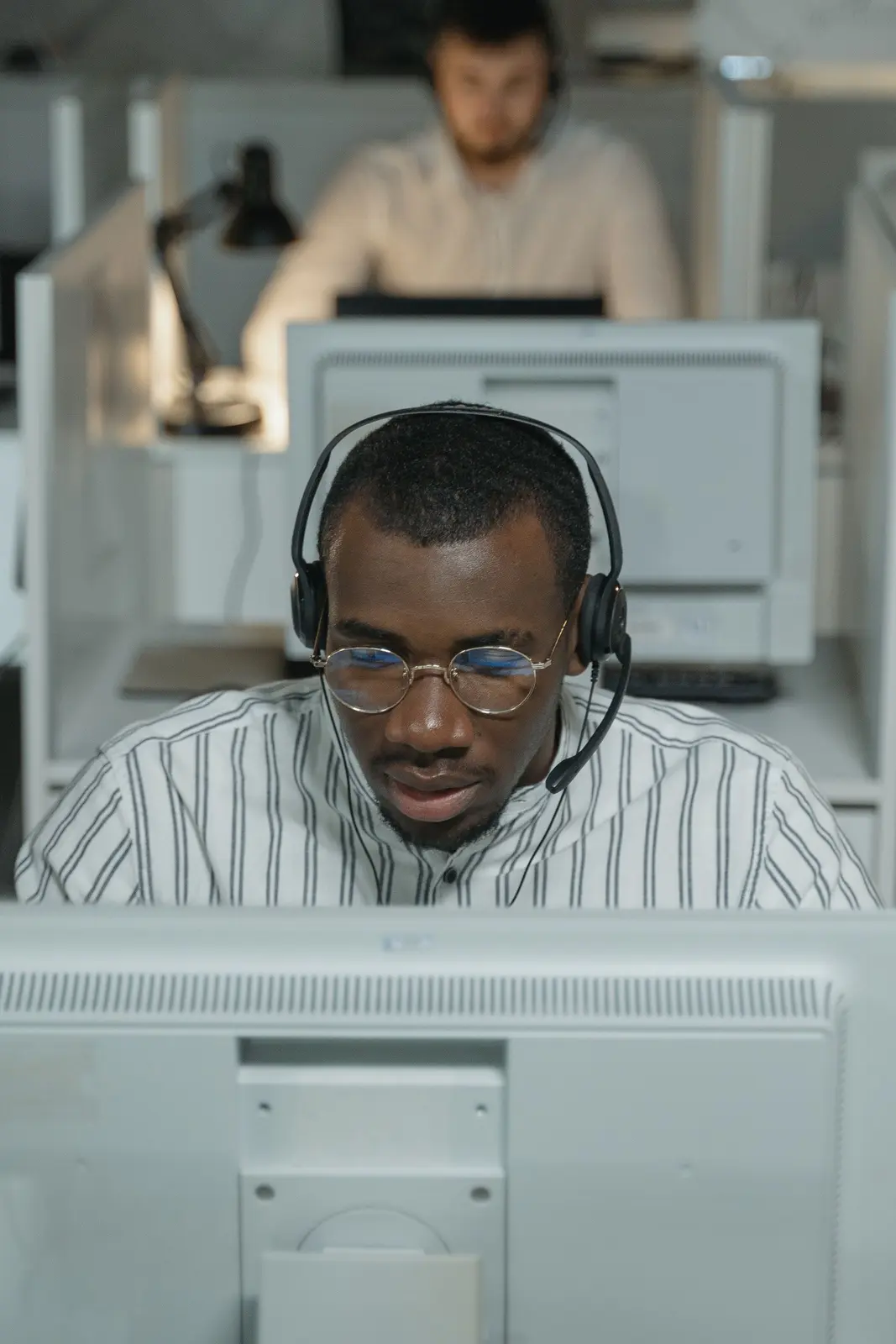 Black communications professional using a business headset and computer